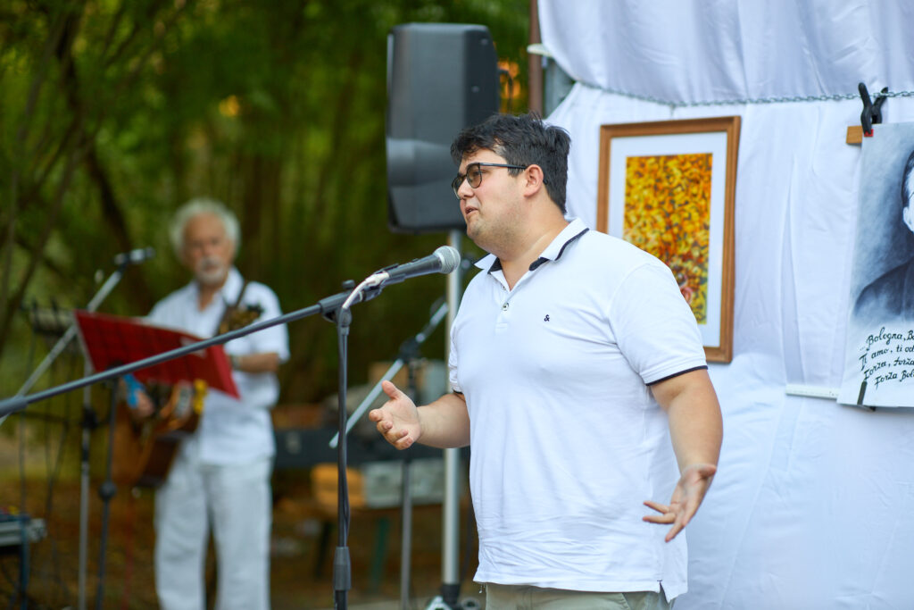 Uomo che parla al microfono su palco