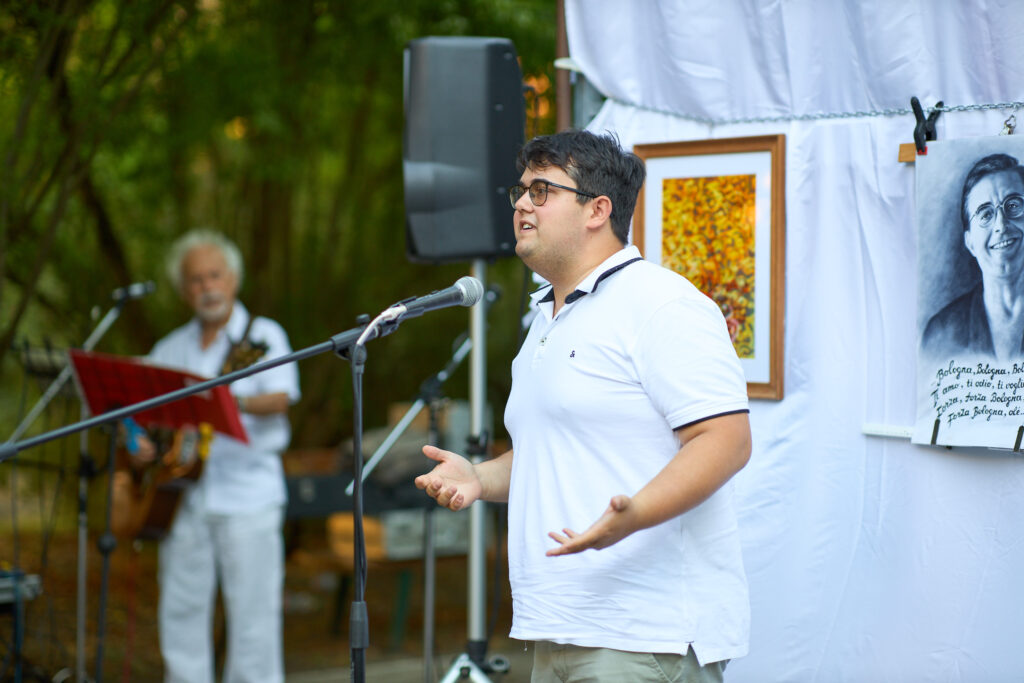 Uomo parla al microfono in evento all'aperto