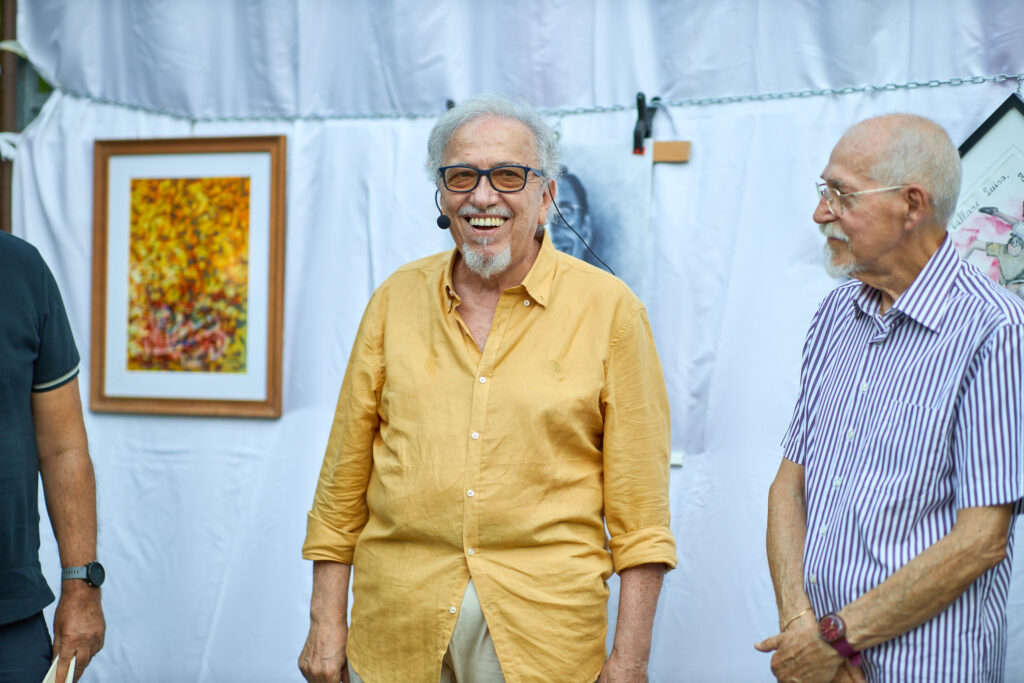 Due uomini anziani sorridono in un evento culturale